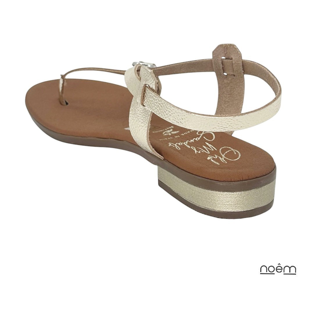 Sandalias planas doradas de piel con tiras finas y hebilla ajustable. Elegantes y cómodas para verano.